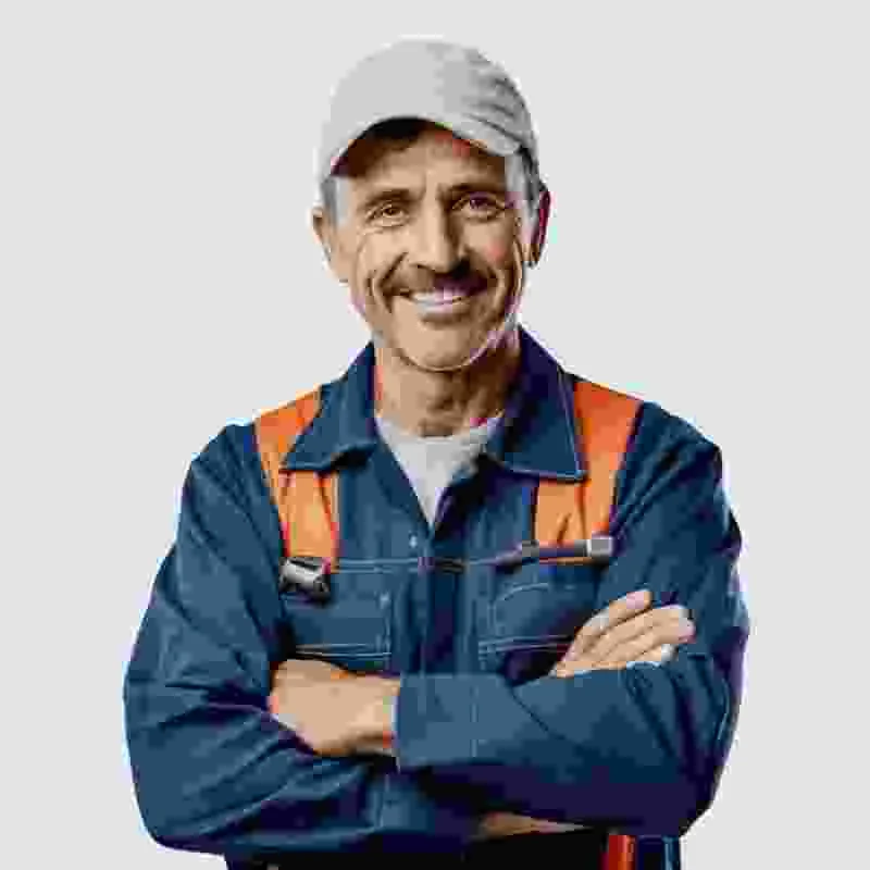 עובד בקסדה כתומה ובגדי עבודה עומד עם ידיים משולבות על רקע בהיר